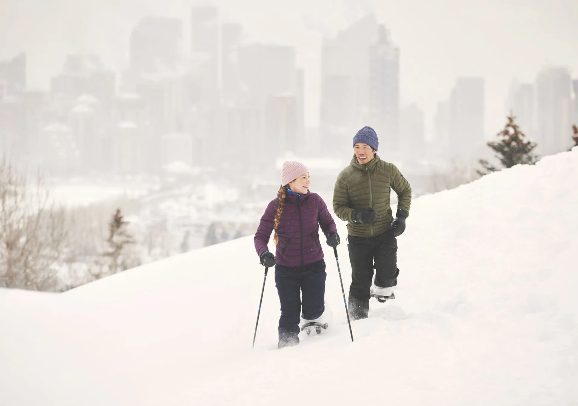 couple snowshoeing through Shaganappi Point Golf Course
