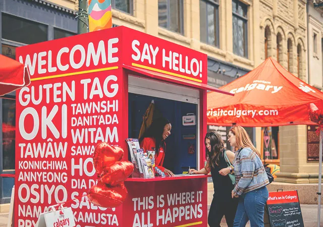 A travel counsellor on Stephen Avenue helps two visitors plan their trip.