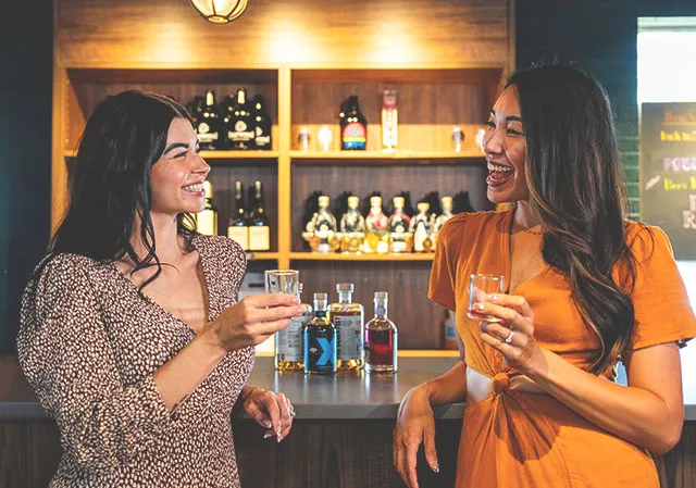 two ladies taste spirits at the bar of Burwood Distillery