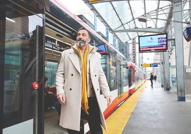 man exiting the Calgary CTrain onto a downtown platform