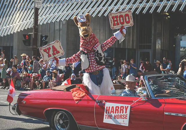 Harry the Horse Calgary Stampede Mascot riding in a car in the Stampede Parade downtown