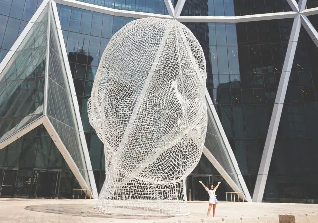 woman posing for a photo in front of Wonderland Sculpture