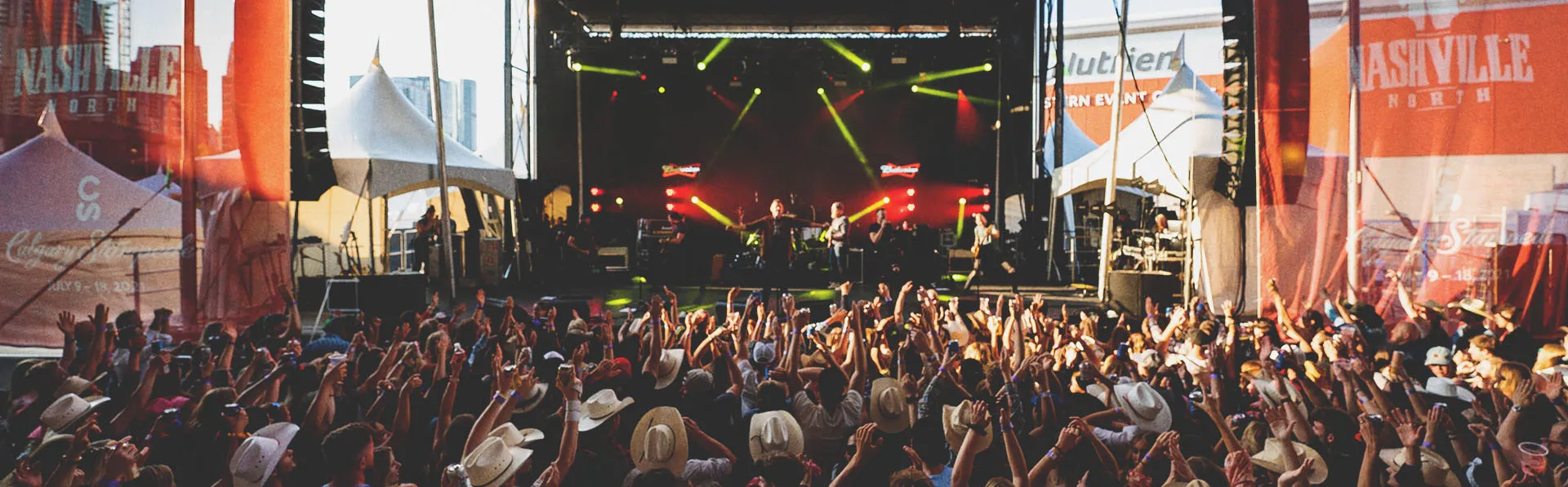 crowd cheering on a musician at the Nashville North tent on Calgary Stampede grounds