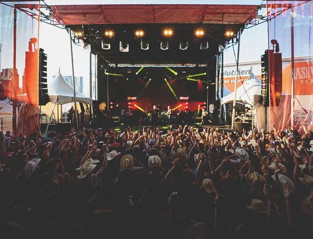 crowd cheering on a musician at the Nashville North tent on Calgary Stampede grounds