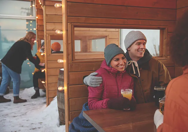 friends on the Cabin Brewing patio during winter