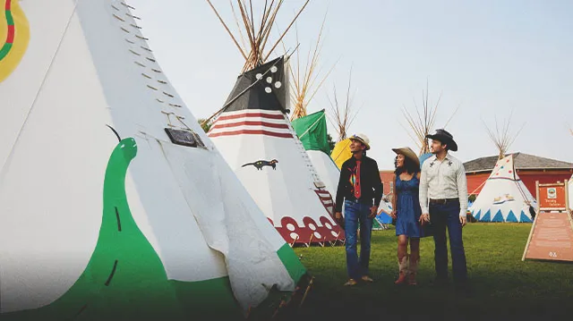 couple taking a tour of Elbow River Indigenous Camp on the Calgary Stampede Grounds