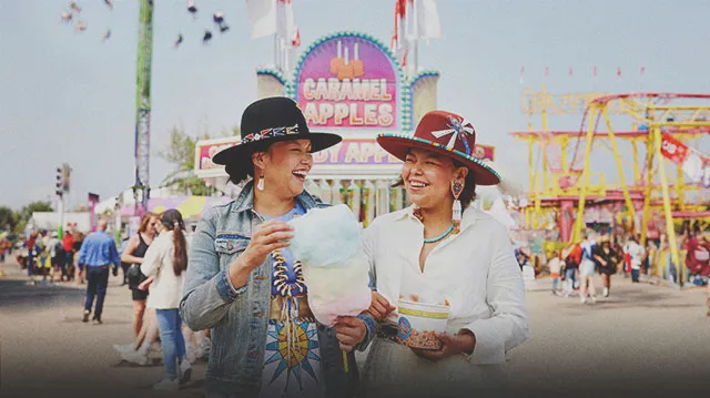 two Indigenous ladies enjoying some classic midway food at Calgary Stampede
