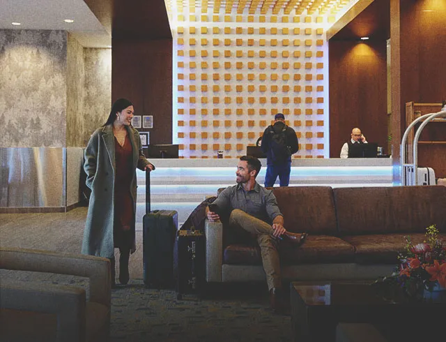 two people greet each other in the lobby of a Calgary Hotel