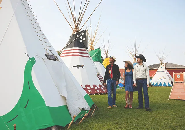 couple walking with an Indigenous guide through Elbow River Camp