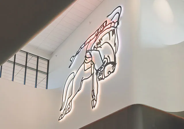 The Neon Cowboy sign shines brightly in the BMO Centre.