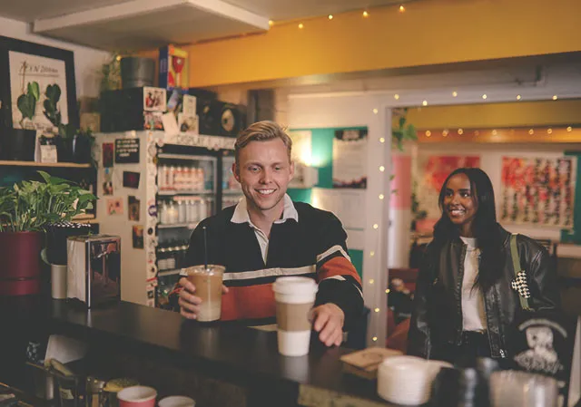 couple grabbing coffees inside I Love You Coffee Shop