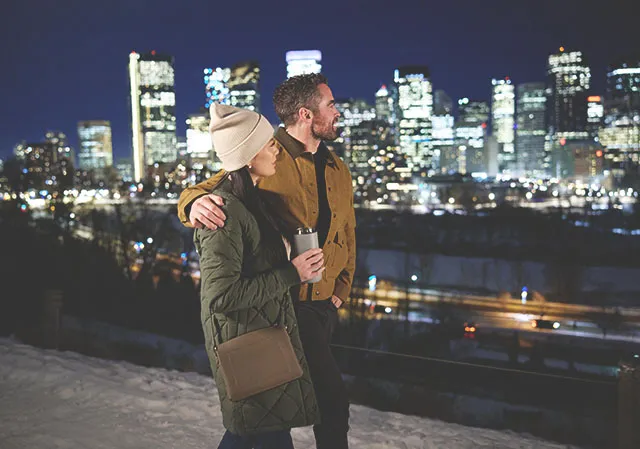 couple walking along Crescent Road admiring the skyline at night during winter