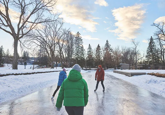 friend group skating the ice trail at Bowness Park