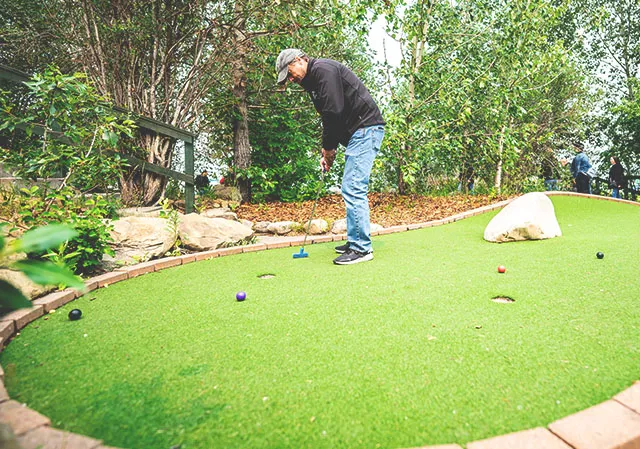 a man is playing golf at Winsport mini golf course