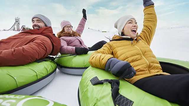 group of friends tubing at Winsports tube park during winter