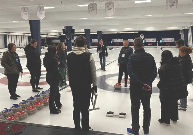 a group of people attending a private curling class at the Glencoe Club