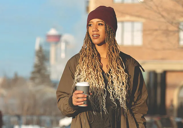 a woman carry a cup of coffee and explore the shops in Inglewood