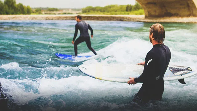 2 people surfing on the Bow River