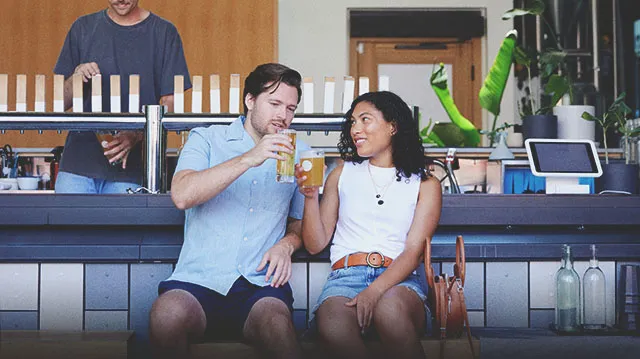 Couple enjoying pints of beer outside at 33 Acres Brewing Co in Calgary's beltline