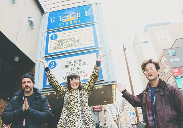 a group of friends smiling in front of Globe Cinema