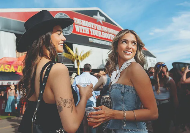 two ladies smiling and enjoying Cowboys Music Festival during Stampede