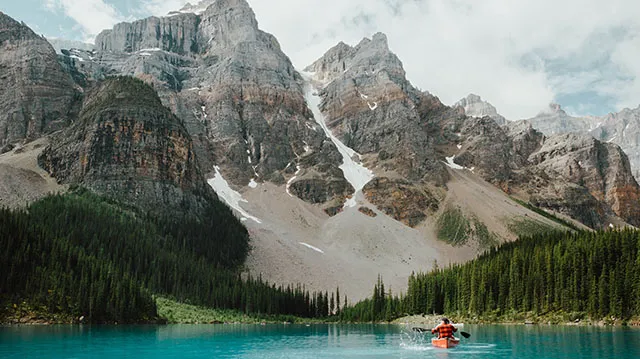 Person in a canoe on Moraine Lake surrounded by mountains in Banff National Park