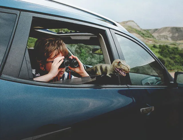 Boy in car with binoculars