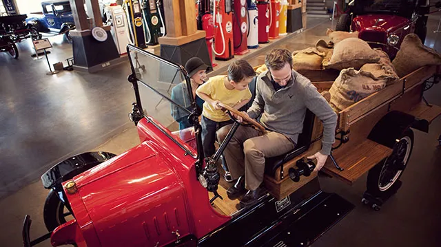 family experiencing a car at the Gasoline Alley Museum Heritage Park