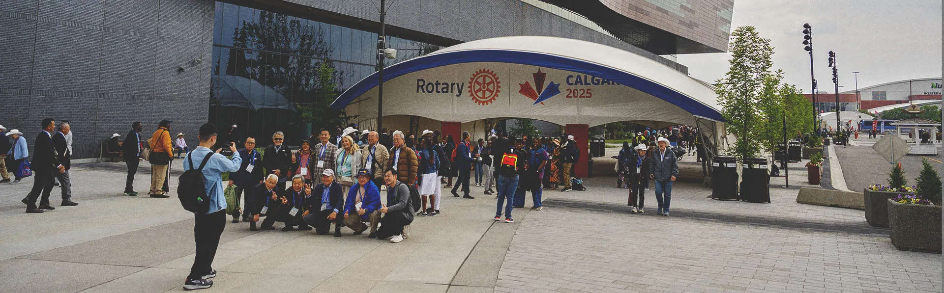 Group of Rotary attendees posing for a photo in front of a large entrance gate