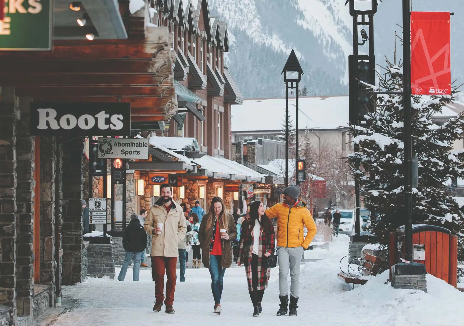 A group of friends walking down a snowy main street in Banff